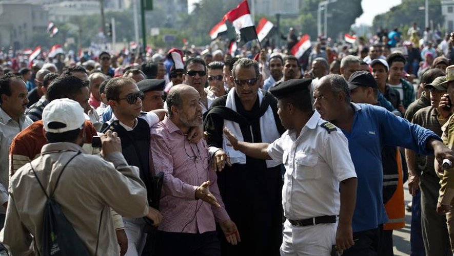 Un policier égyptien arrête un homme soupçonné d'être membre des Frères musulmans le 6 octobre 2013 sur la place Tahrir au Caire