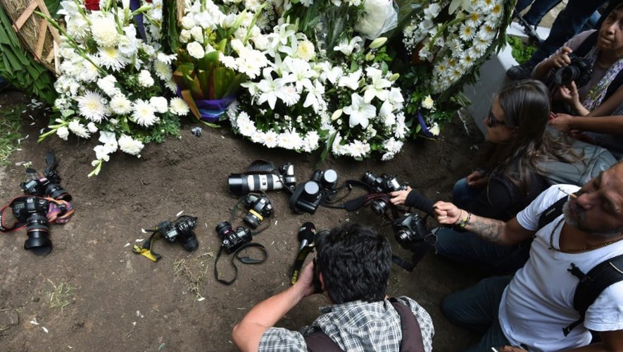 Des collègues du journaliste mexicain assassiné déposent leur caméra sur sa tombe, à Mexico City, le 3 août 2015
