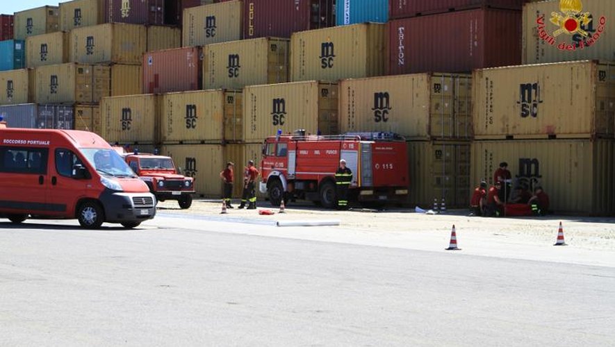 Des pompiers italiens à côtés des containeurs transportant des armes et composants chimiques syriens sur le port de Gioia Tauro, dans le sud de l'Italie, le 2 juillet 2014