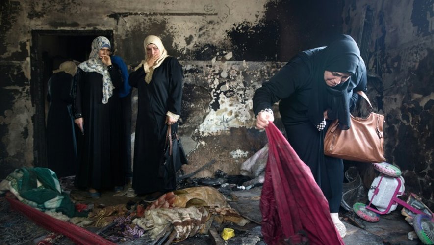 Des palestiniennes évaluent les dégâts dans la maison du bébé palestinien mort dans un incendie imputé à des extrémistes juifs israéliens, le 4 août 2015 à Douma