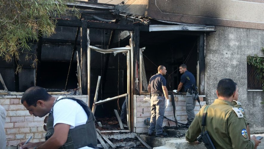 Les forces de sécurité israéliennes inspectent la maison du bébé palestinien mort dans un incendie imputé à des extrémistes juifs israéliens, le 4 août 2015 à Douma