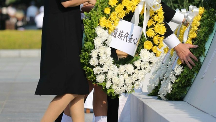 Des proches d'une des victimes du bombardement nucléaire déposent une gerbe le 6 août 2015 à Hiroshima, pour la cérémonie de commémoration du 70è anniversaire