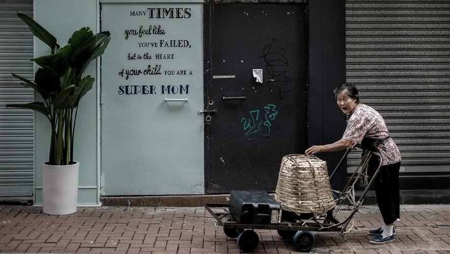 Une femme âgée pousse un chariot dans les rues de Hong Kong, le 24 septembre 2013