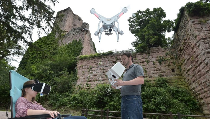 Une femme porte un casque vidéo sur les yeux et visite le château de Kintzheim grâce à la diffusion d'images haute définition tournées par un drone, le 21 juin 2016