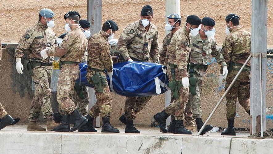 Des soldats italiens portent le corps d'une victime du naufrage à Lampedusa, le 7 octobre 2013