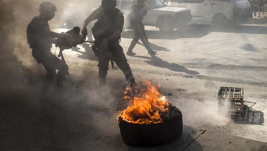 Des policiers anti-émeutes éteignent un incendie dans une rue du Caire, alors que les partisans des Frères musulmans manifestent, le 3 juillet 2014