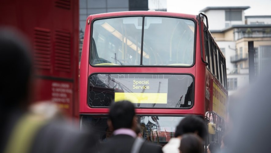 Les usagers s'apprêtent à s'engouffrer dans un bus à Victoria Station dans le centre de Londres, le 6 août 2015