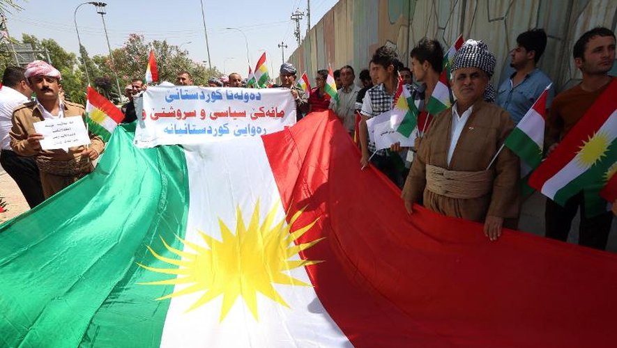 Des Kurdes agitent le drapeau du Kurdistan irakien lors d'une manifestation en faveur de l'indépendance de cette région autonome, le 3 juillet 2014 devant le Parlement à Erbil
