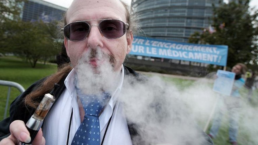Un homme fume avec une cigarette électronique devant le Parlement européen à Strasbourg, le 7 octobre 2013