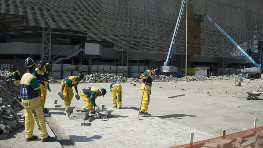 Des ouvriers s'activent à la construction du stade olympique de Rio de Janeiro, le 5 août 2015, un an avant le début des épreuves olympiques