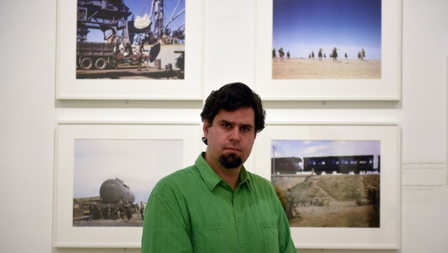 Istvan Viragvölgyi du Centre Robert Capa de Budapest pose devant des photographies de l'artiste hongrois dans le cadre d'une exposition "Capa en couleurs", le 2 juillet 2015