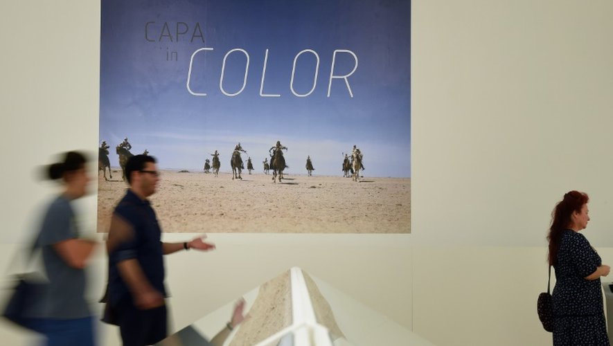 Des visiteurs s'intéressent aux photographies en couleur de Robert Capa, dans le cadre d'une exposition à Budapest le 2 juillet 2015