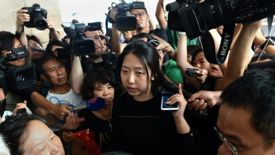 Une représentante de la Malaysia Airlines au milieu des familles des victimes rassemblées le 6 août 2015 devant les bureaux de la compagnie aérienne à Pékin
