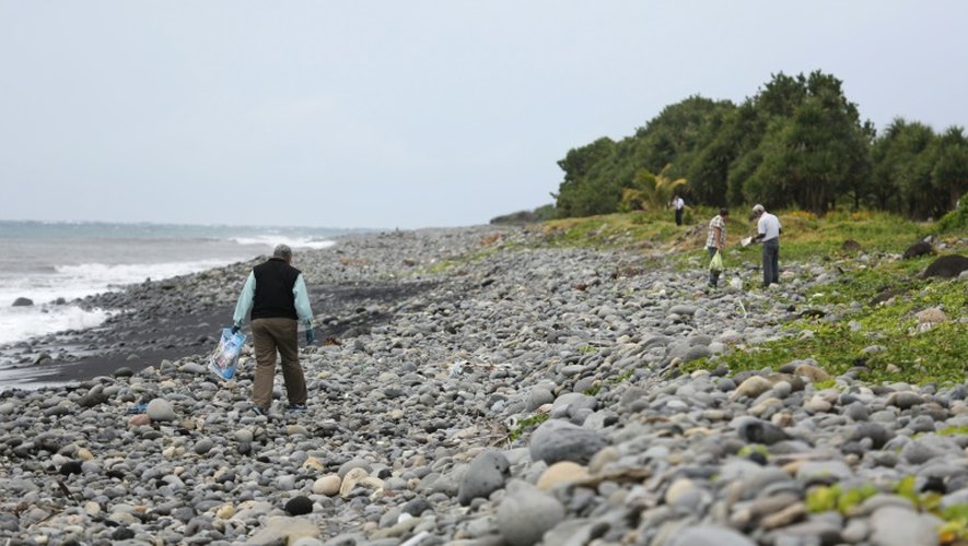 Un expert malaisien (g) cherche des débris du vol MH370 sur la plage de Saint-André de La Réunion, le 6 août 2015