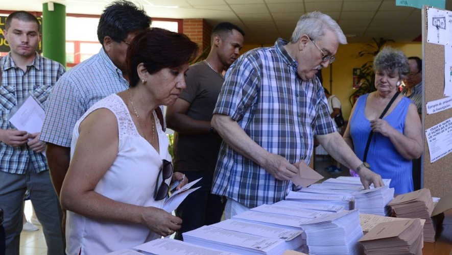 Des électeurs choisissent leurs bulletins de vote pour le scrutin législatif dans un bureau de vote de Madrid, le 26 juin 2016