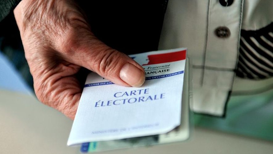 Un électeur présente sa carte électorale le 17 juillet 2012 à Hénin-Beaumont