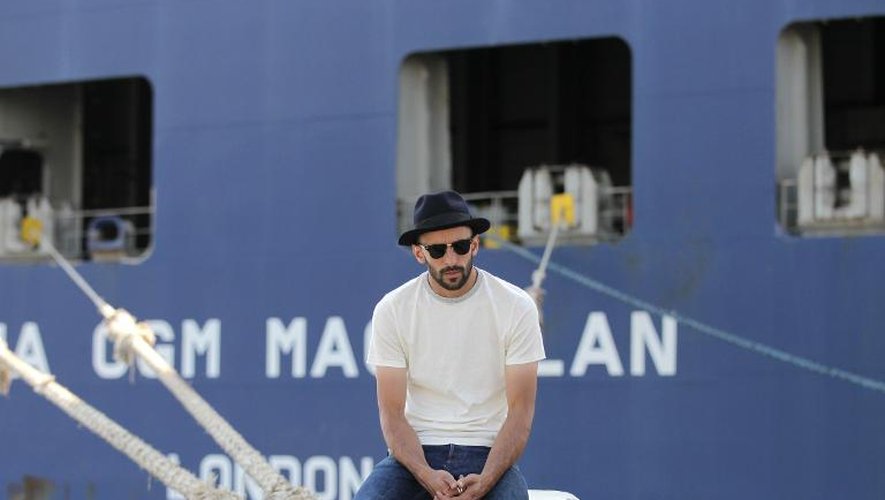 Le photographe français JR pose devant le cargo Magellan de la CMA-CGM, au Havre le 4 juillet 2014