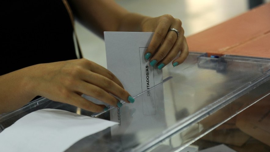 Une femme met son bulletin dans l'urne lors des élections législatives en Espagne, le 26 juin 2016