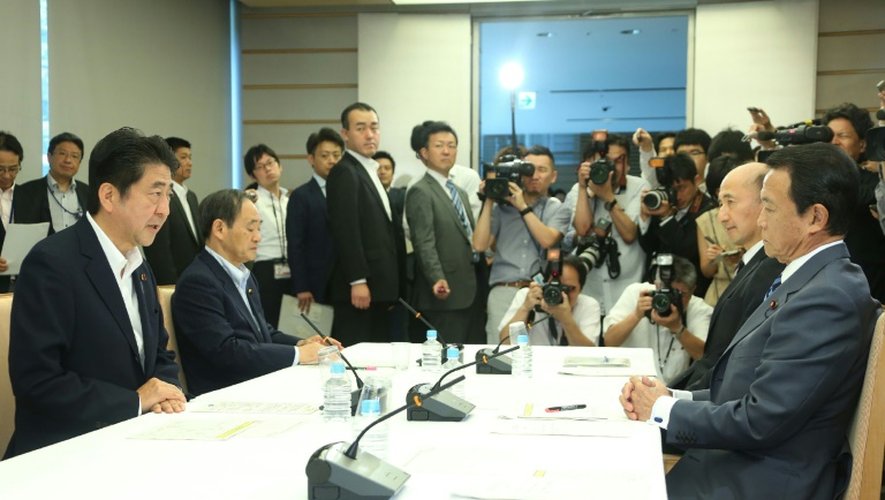 Le Premier ministre japonais Shinzo Abe (G) lors d'une réunion avec son ministre des Finances Taro Aso (D) et un haut responsable de la Banque du Japon le 27 juin 2016 à Tokyo