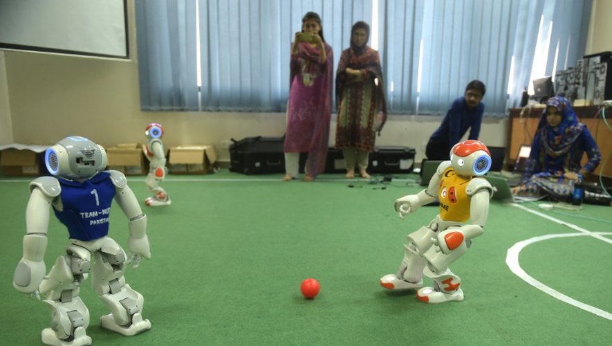 Des étudiants pakistanais membres de l'équipe de robotique observent leurs robots en plein match à l'université de sciences et de technologie d'Islamabad, le 9 mai 2016