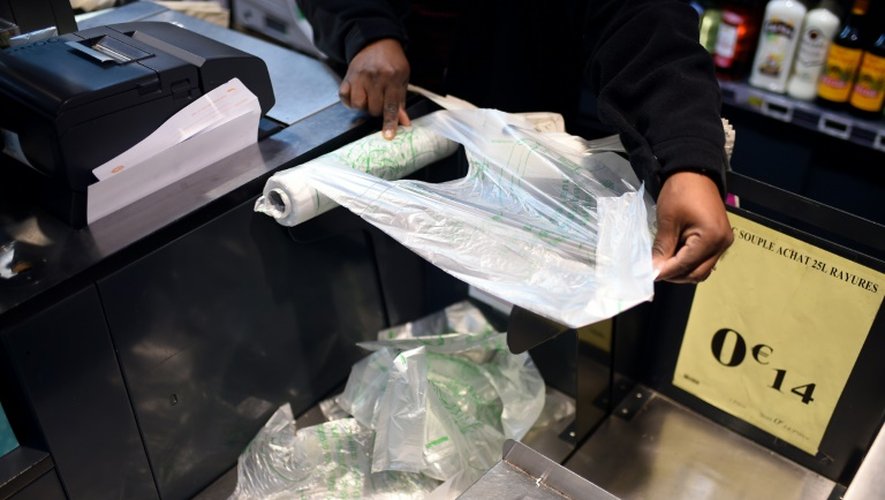 Un employé de supermarché prend un sac plastique à usage unique à Paris, le 28 décembre 2015