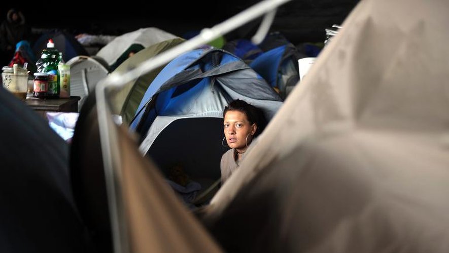 Une femme sortant de sa tente dans un camp de demandeurs d'asile albanais, près de la gare Perrache, à Lyon, le 11 octobre 2013