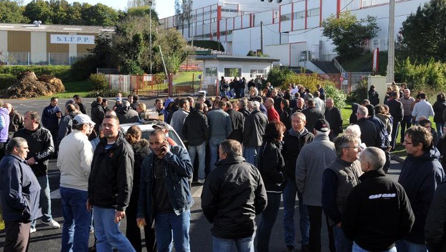 Des salariés devant l'entrée de l'abattoir le 9 octobre 2013 à Lampaul-Guimilau