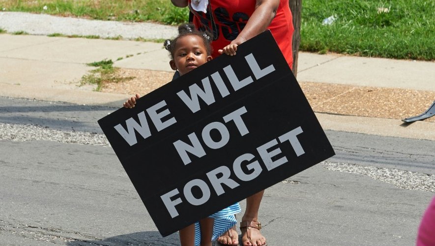 Une fillette porte une pancarte où est inscrit "Nous n'oublierons pas" lors de la marche à Ferguson, le 8 août 2015, un an après la mort d'un jeune noir tué par un policier blanc