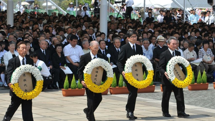 Des officiels dont le maire de Nagasaki Tomihisa Taue (2e d), déposent une gerbe, le 9 août 2015 à Nagasaki, lors des cérémonies du souvenir 70 ans après l'attaque nucléaire contre la ville