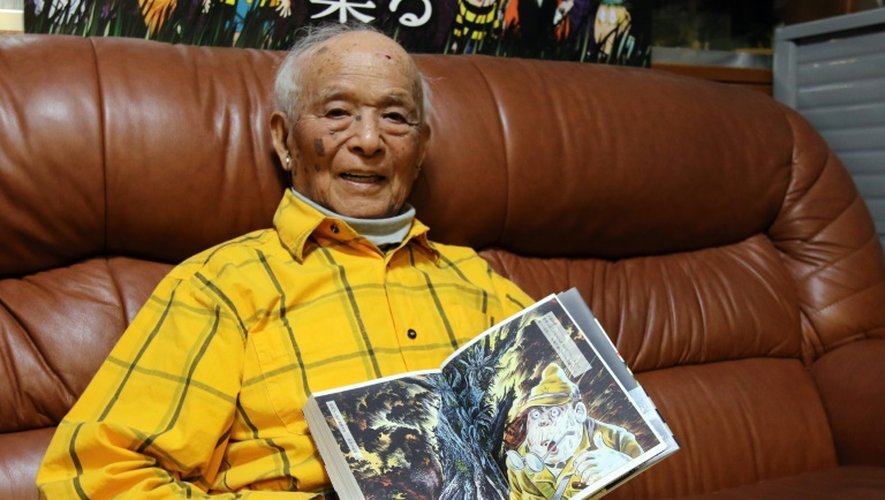 Shigeru Mizuki, 93 ans et créateur de mangas montre un de ses mangas, lors d'un entretien avec l'AFP à Tokyo le 12 mai 2015, au cours duquel il évoque ses souvenirs de guerre