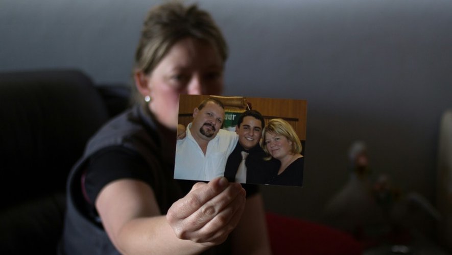 Carina Janse Van Rensburg, l'épouse du sud-africain tué dans la prise d'otages d'un hôtel de Savaré au Mali, montre une photo de son mari (g) à Pretoria en Afrique du Sud, le 9 août 2015