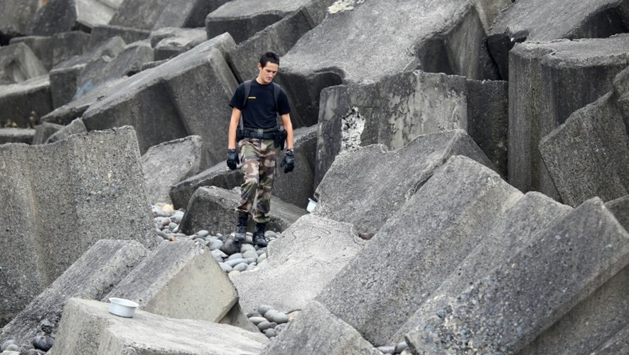Un gendarme cherche des traces de débris du MH370 sur la plage de Sainte-Marie de la Reunion, le 8 août 2015