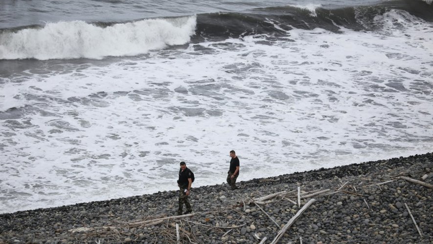 Des gendarmes cherchent des débris du MH370 sur la plage de Sainte-Marie de la Reunion, le 8 août 2015