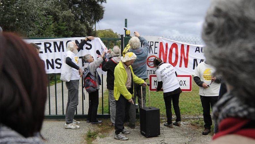 Des manifestants anti-OGM soudent symboliquement la grille d'entrée d'un site de Monsanto à Monbéqui, le 12 octobre 2013