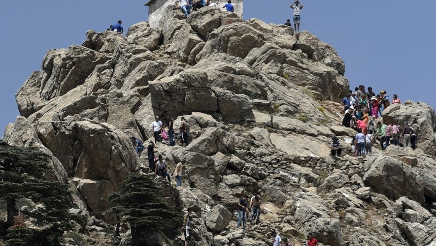 Des pélerins grimpent jusqu'au Rocher de la prière du zénith (Azro Nethor) qui culmine à 1.884 mètres d'altitude en Kabylie, le 31 juillet 2015
