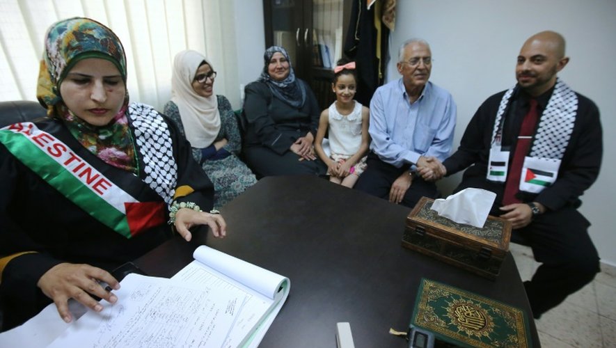 Tahrir Hamad (g), première juge à célébrer des mariages scelle une union entre Thaer (d) et Rawan (2e g) selon la loi islamique à Ramallah, le 6 août 2015