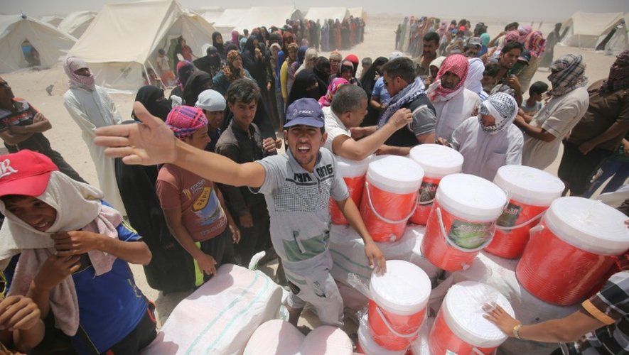 Distribution d'aide dans un camp de déplacés ayant fui les combats à Fallouja en Irak, à Amriyat al-Fallujah le 27 juin 2016