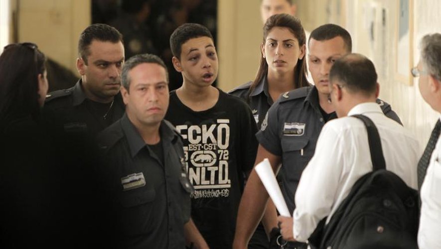 Le jeune américano-palestinien Tariq Abu Khdeir qui aurait été battu lors de son arrestation par la police, arrive, escorté de policiers israéliens, à une audience judiciaire au tribunal de Jérusalem le 6 juillet 2014