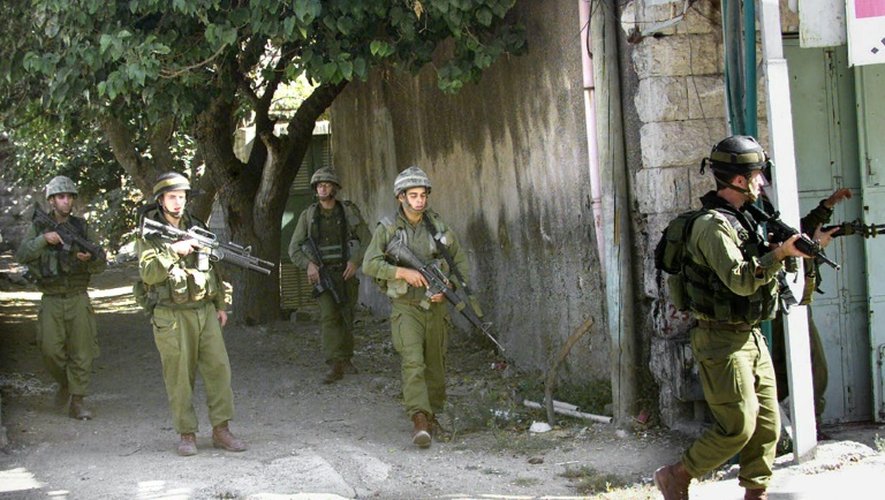 Des soldats de l'armée israélienne patrouillent à Hébron en Territoires palestiniens, en octobre 2003