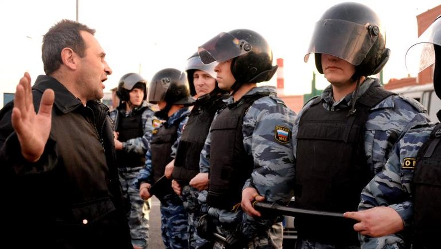 Un homme face aux policiers anti-émeutes dans le sud de Moscou, le 13 octobre 2013
