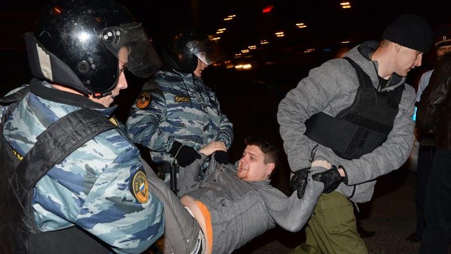 Des policiers anti-émeutes évacuent une personne qui participait à une manifesttaion non-autorisée dans le sud de Moscou, le 13 octobre 2013