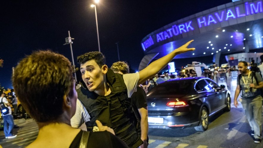 Un policier turc à l'aéroport Ataturk d'Istanbul s'adresse aux passagers après la triple attaque-suicide, le 28 juin 2016