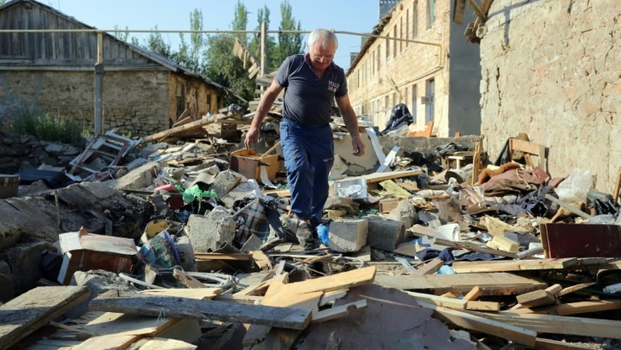 Un homme marche sur les débris de sa maison, détruite par les combats entre les séparatistes prorusses et les forces ukrainiennes, le 10 août 2015 dans la région de Donetsk