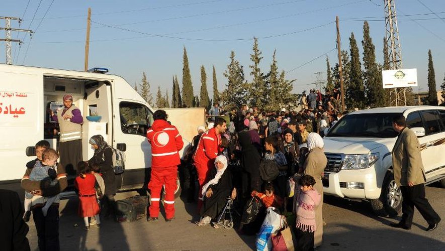 Des membres du Croissant rouge syrien évacuent des femmes et des enfants dans une banlieue de Damas, le 12 octobre 2013