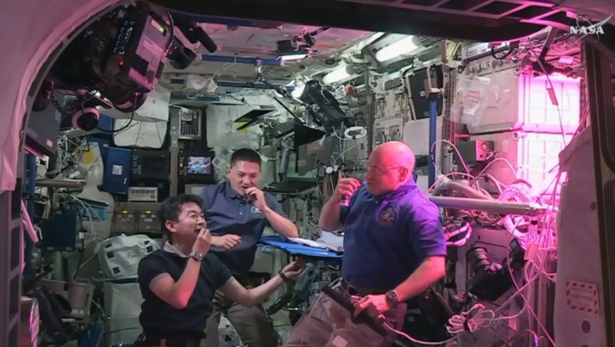 Les astronautes Kimiya Yui, Kjell Lindgren et Scott Kelly à bord de la Station spatiale internationale mangent de la laitue romaine rouge "spatiale" qui a poussé dans l'espace, le 10 août 2015