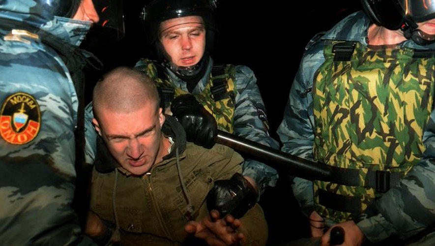 Des policiers arrêtent un homme lors d'émeutes anti-immigrés, le 13 octobre 2013 à Moscou