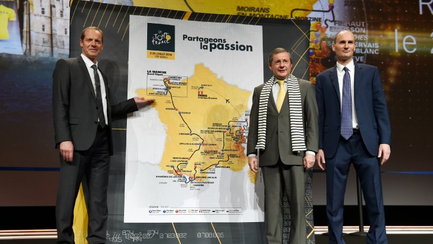 Le directeur du Tour de France Christian Prudhomme (g), le président du Conseil départemental de La Manche Phillipe Bas et le président d'ASO Jean-Etienne Amaury posent devant la carte de la Grande Boucle 2016, le 20 octobre 2015 à Paris