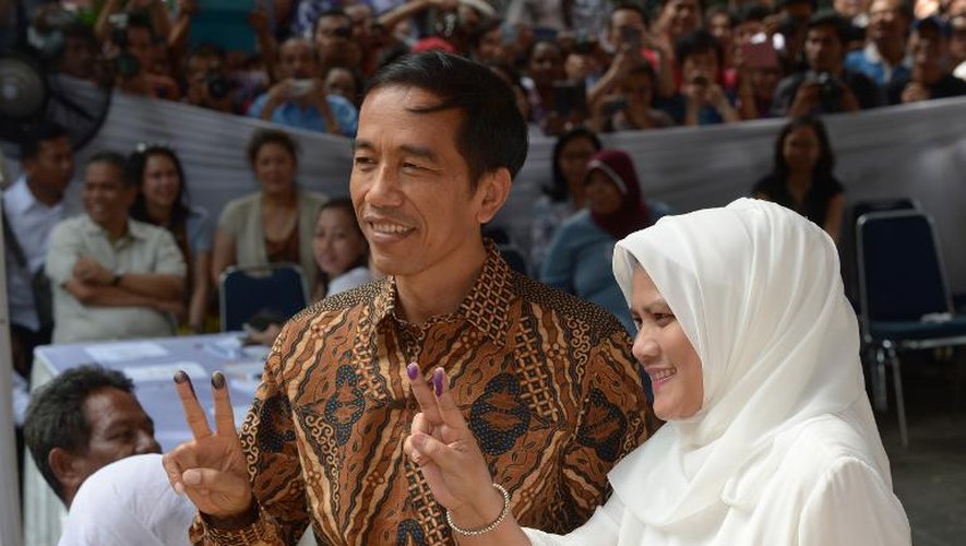 Joko Widodo (g), gouverneur de Jakarta et son épouse Iriana Widodo (d) votent dans la capitale indonésienne le 9 juillet 2014