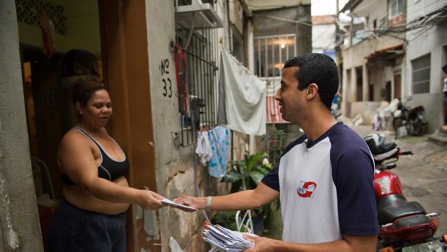 Un employé de "Facteur Ami" distribue le courrier dans la favela Rocinha, à Rio le 4 octobre 2013
