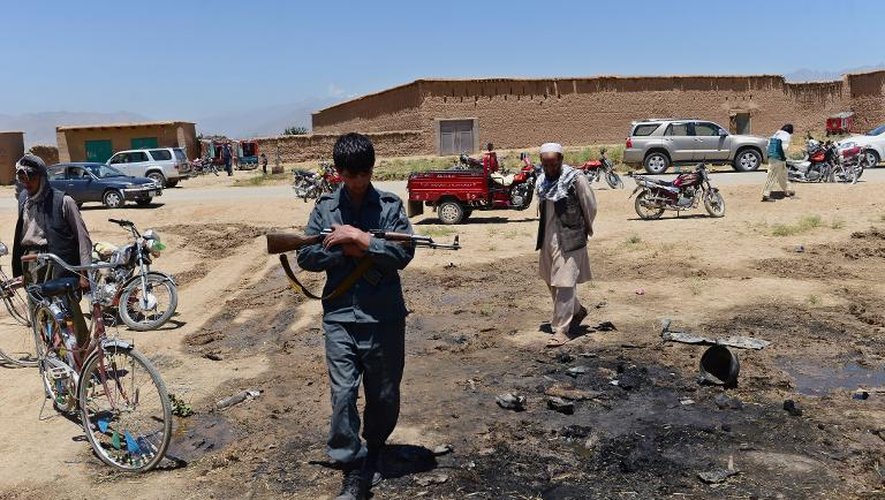 Un policier afghan sur le site d'un attentat-suicide qui a fait 16 morts dont 10 civils, le 8 juillet 2014 dans la région de Parwan